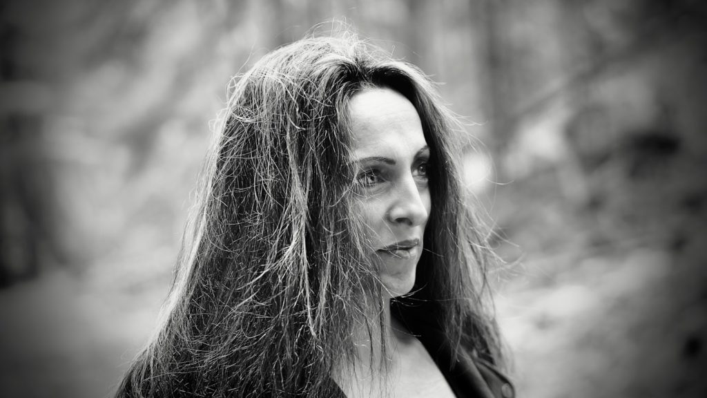 A woman with long hair looks off to the side.