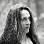 A woman with long hair looks off to the side.