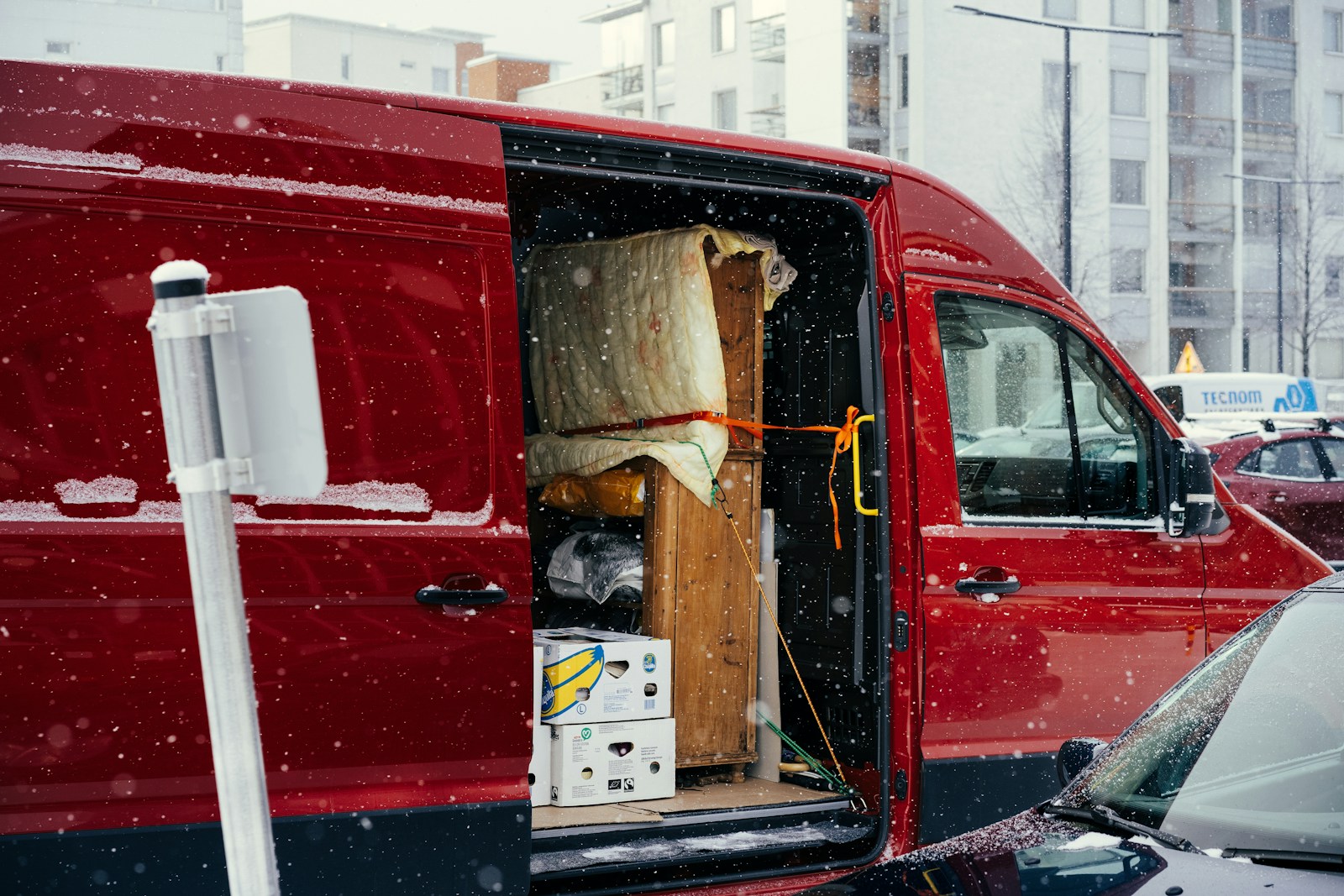 A red van is parked on the side of the road