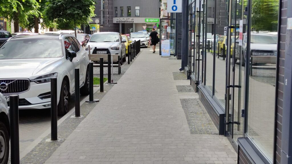 a row of parked cars sitting next to a sidewalk