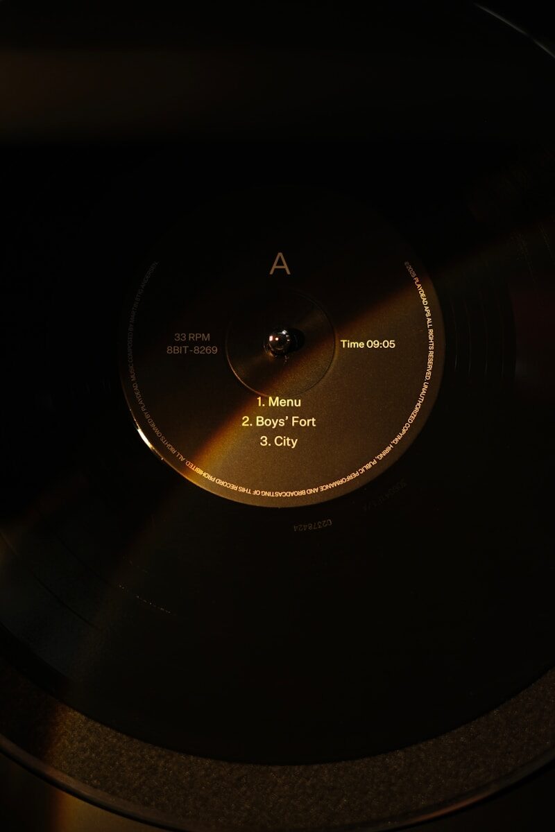A vinyl record spinning on a turntable in low light.