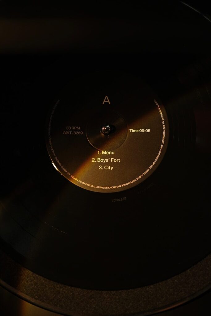 A vinyl record spinning on a turntable in low light.